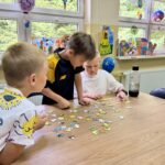 Spotkanie czytelnicze W krainie Muminków- układanie puzzli w grupach